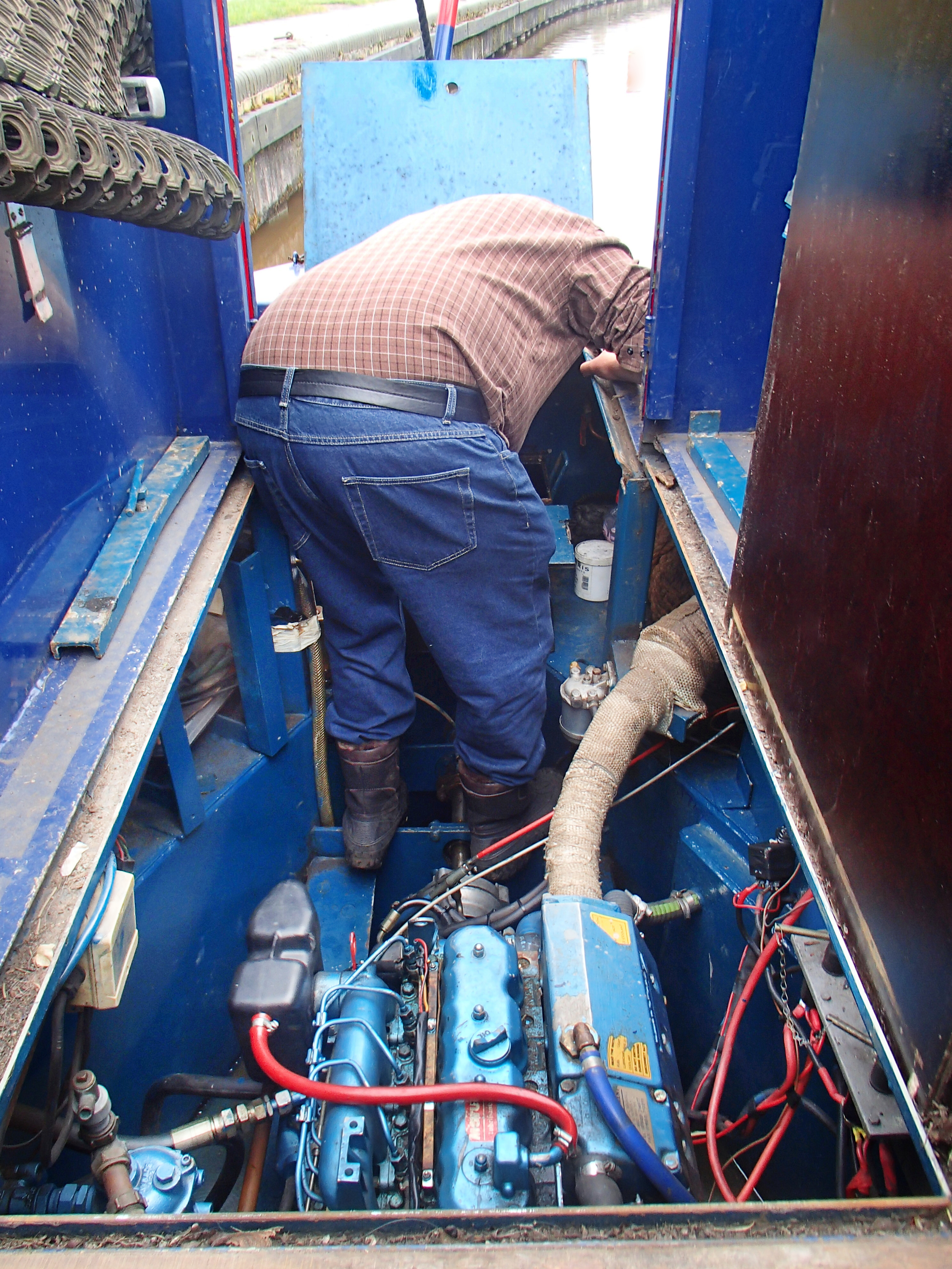 A photograph of one of the owner's in the engine bay perfoming regular maintenence.
